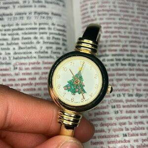 Gold colored watch 🧈⏰ with white face and Xmas tree🦴🎄